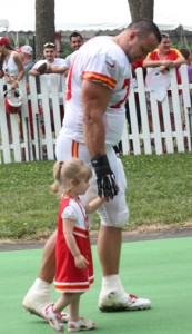 July 26, 2014; St. Joseph, MO; Chiefs defensive lineman Mike DeVito walked off the field holding the hand of Chiefs fan Lauren King, who won a contest to take part in the team's helmet walk after practice.