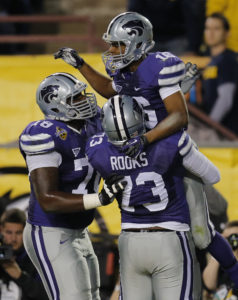 Kansas State wide receiver Tyler Lockett (16) celebrate his touchdown with teammates Tavon Rooks (73) and Cornelius Lucas (78) during the first half of the Buffalo Wild Wings Bowl NCAA college football game against Michigan, Saturday, Dec. 28, 2013, in Tempe, Ariz. (AP Photo/Matt York)
