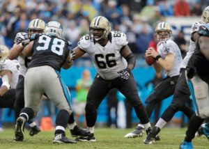 As teammate Brian De La Puente blocks Carolina Panthers' Linden Gaydosh (98), New Orleans Saints' Ben Grubbs (66) looks to help protect quarterback Drew Brees (9) in the pocket during the second half an NFL football game in Charlotte, N.C., Sunday, Dec. 22, 2013. The Panthers won 17-13. (AP Photo/Bob Leverone)