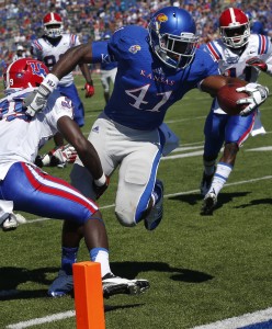 Kansas tight end Jimmay Mundine (41) slips past Louisiana Tech defensive back Xavier Woods (39) for a touchdown during the second half of an NCAA college football game in Lawrence, Kan., Saturday, Sept. 21, 2013. Kansas defeated Louisiana Tech 13-10. (AP Photo/Orlin Wagner)