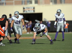 Kansas State defensive players Jonathan Truman (21), Ryan Mueller (44), and Dante Barnett (22) look over the Oklahoma State offense during an NCAA football game in Stillwater, Okla., Saturday, Oct. 5, 2013. Oklahoma State defeated Kansas State 33-29 .(AP Photo/Brody Schmidt)