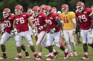 Aug. 18, 2015; St. Joseph, MO; The Chiefs offensive line and quarterback Alex Smith approach the line of scrimmage during a drill at training camp at Missouri Western State University. (Emily DeShazer/The Topeka Capital-Journal)