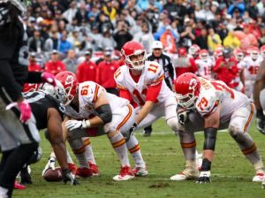 Rain created muddy conditions for the players, but did not stop the Kansas City Chiefs offensive line from providing quarterback Alex Smith with a clean pocket against the Oakland Raiders during the Oct. 16, 2016 matchup at Oakland Coliseum. (Photo courtesy Chiefs PR, Chiefs.com).